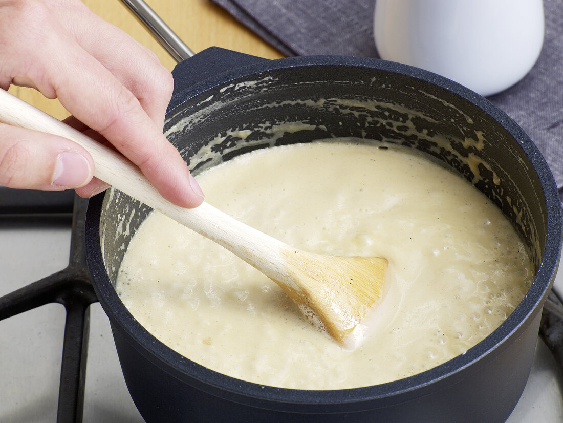 Close-up of hand stirring caramel sauce, step 3