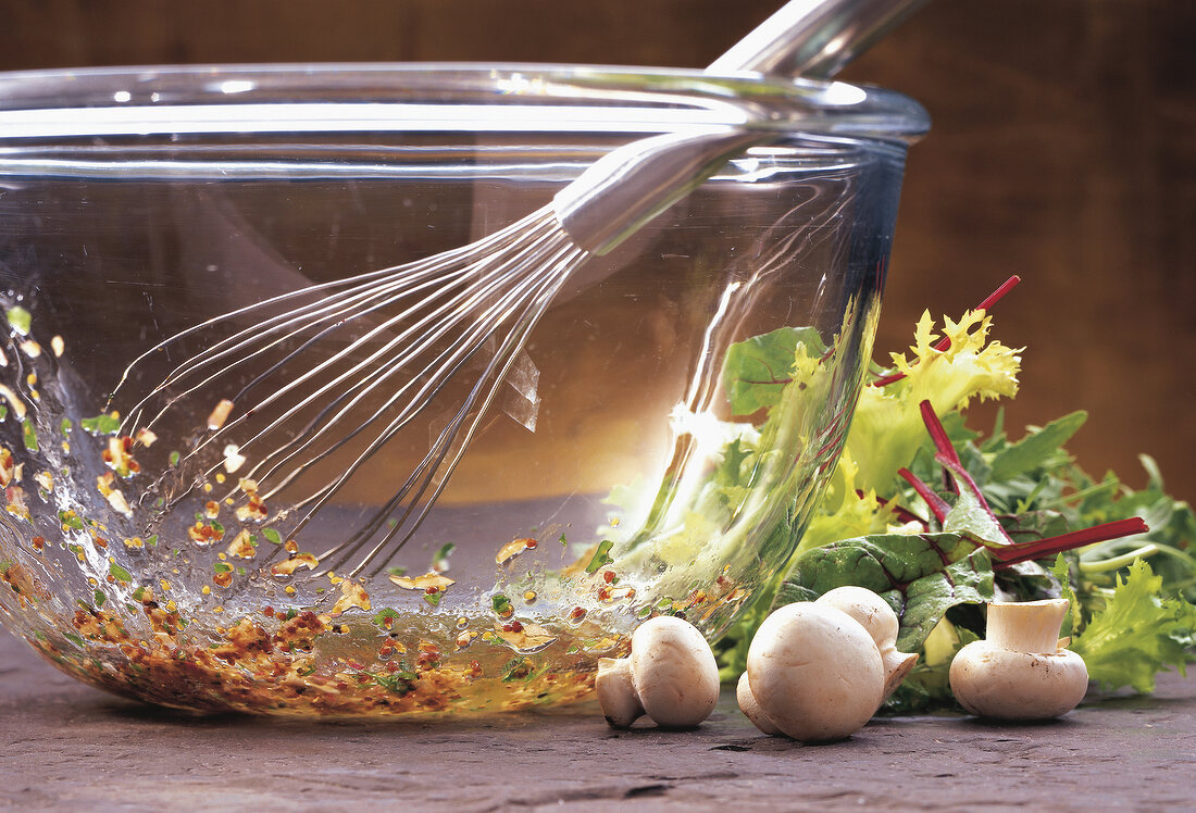 Close-up of whisking herbs for salad in bowl