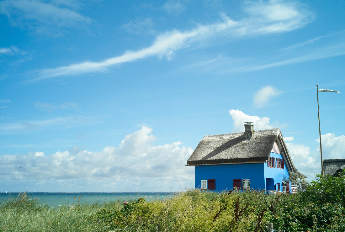 Facade of graswarder blue house on beach at Baltic Sea Coast, Germany
