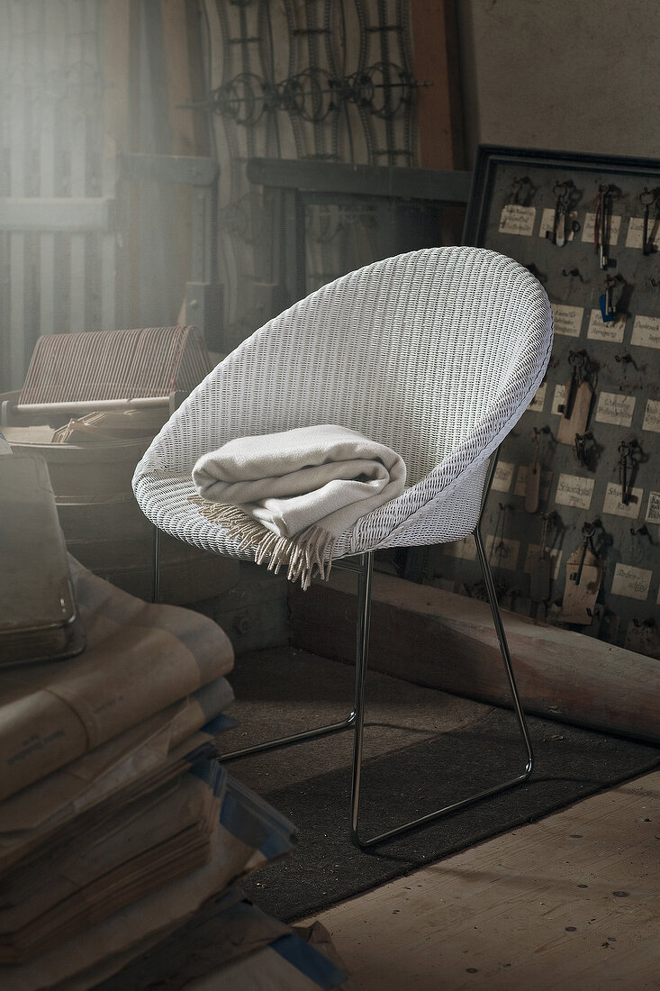 White wicker chair with shawl in room