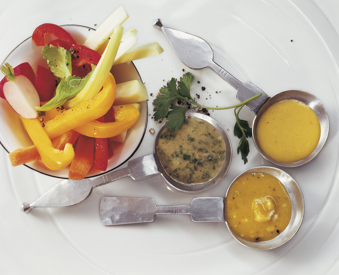 Raw vegetables with three dips on plate