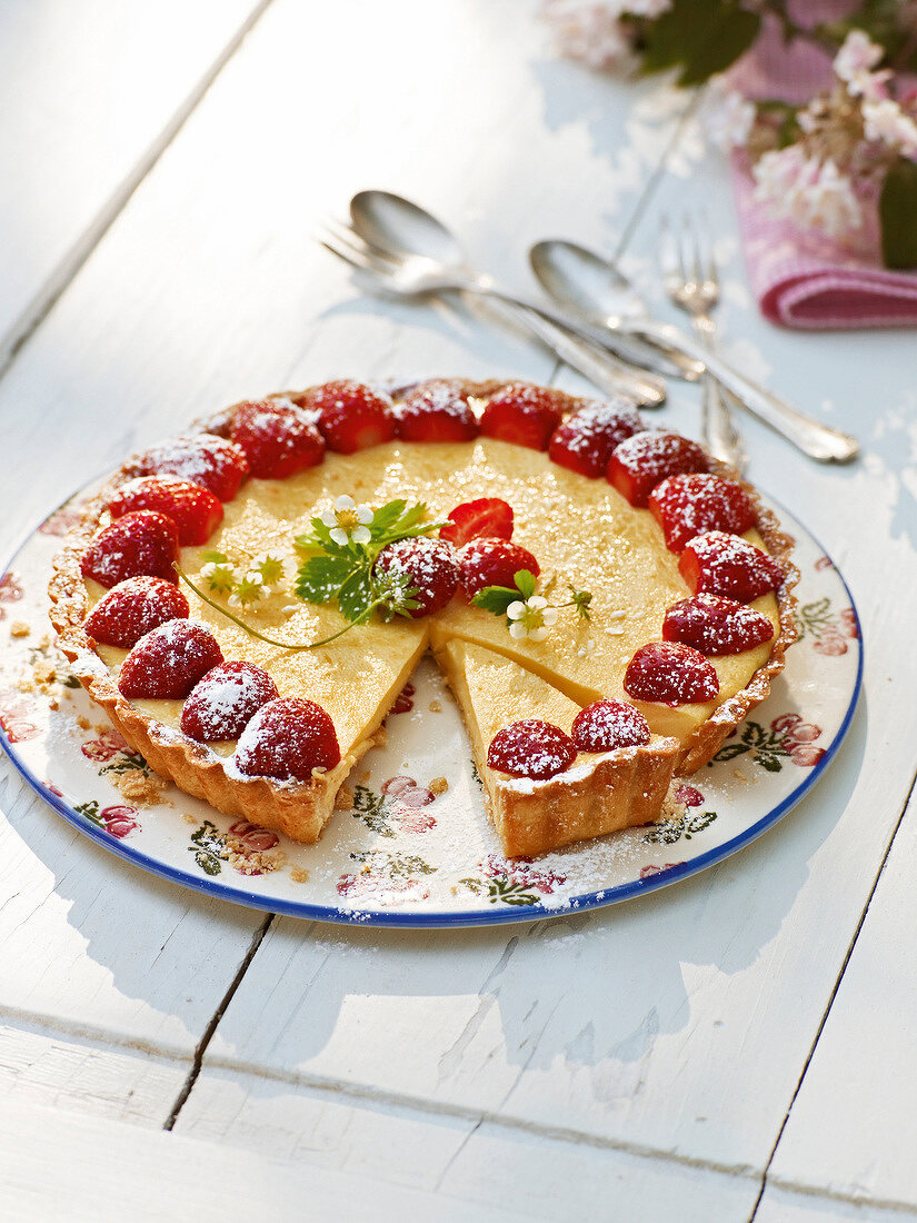 Strawberry cake with orange cream on plate, garden kitchen