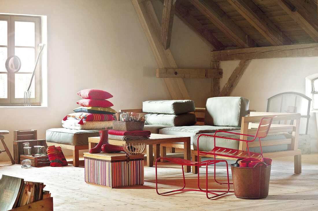 Sofa, chair and red cushions as garden furniture inside room