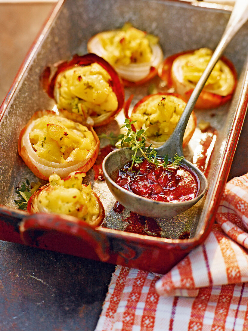 Stuffed onions with onion sauce in baking dish, garden kitchen