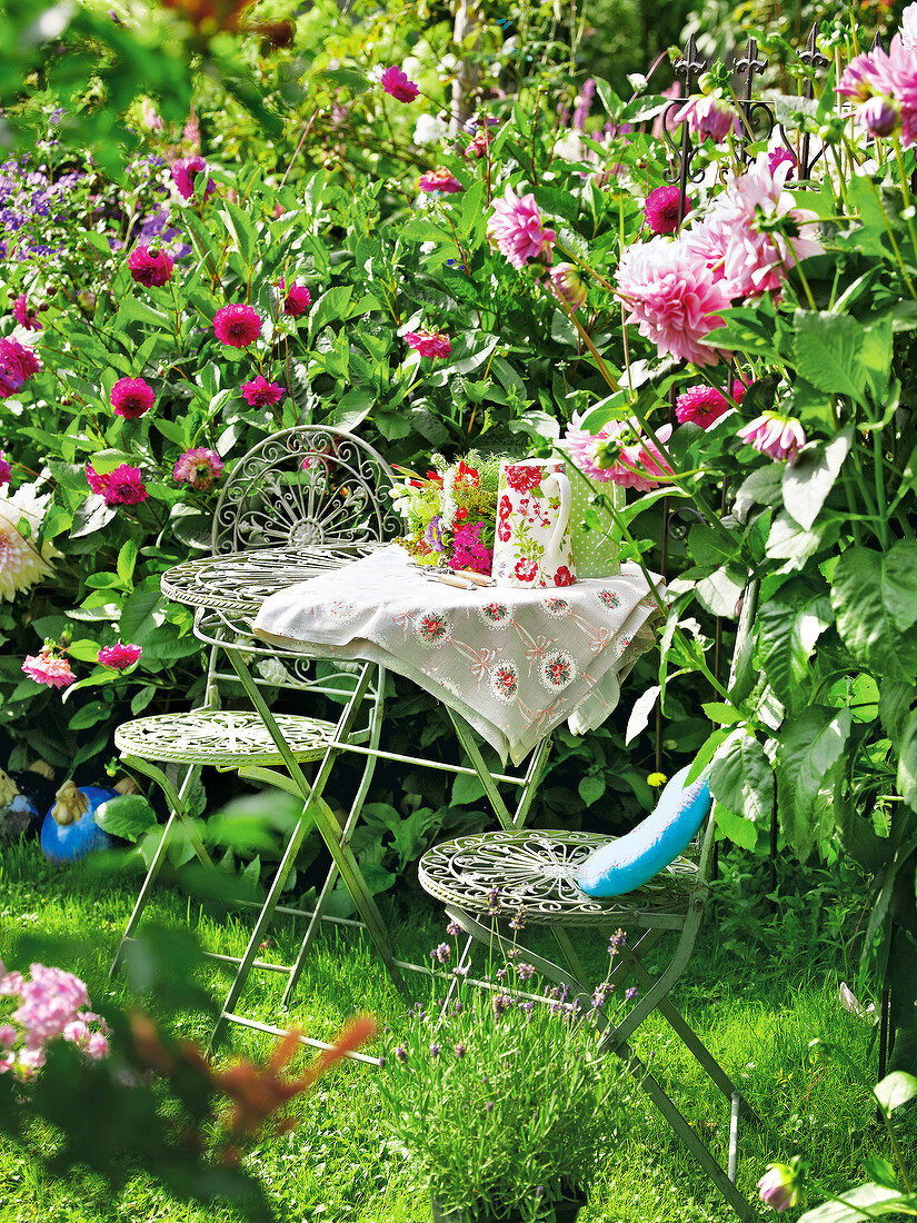 Gartenküche, Kleiner Tisch mit Stühlen, umgeben von Dahlien