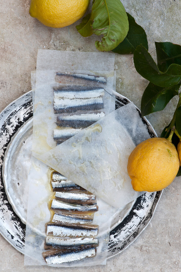 Close-up of anchovies and lemon on tray