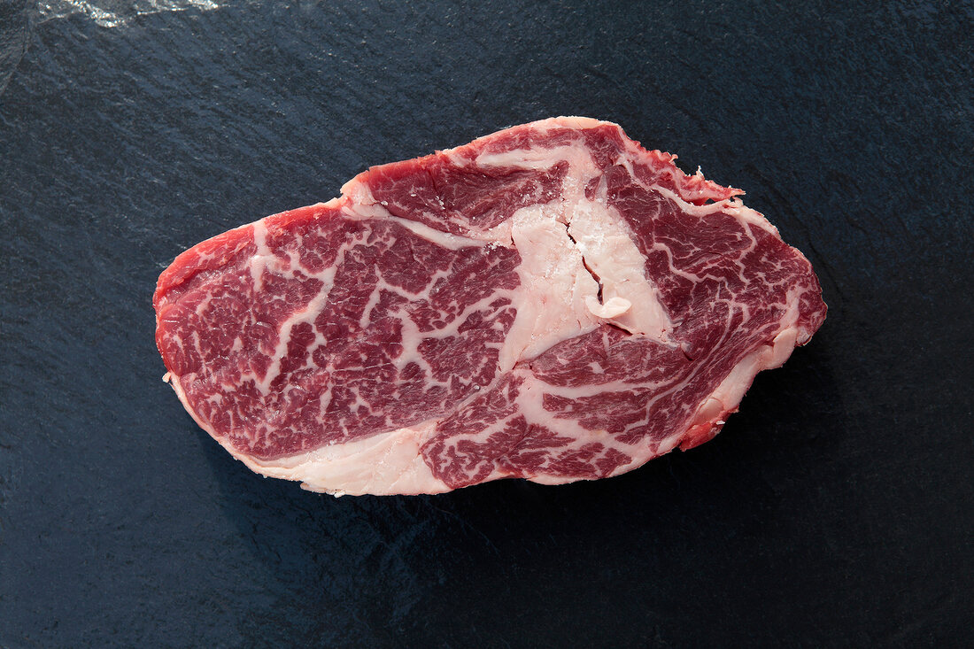 Piece of raw steak on black background