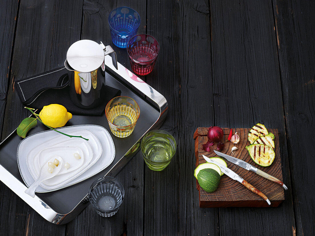 Tray with jug, serving plates and steak knife on wood