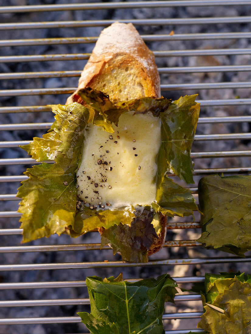 Stuffed vine leaves with fontina cheese and toasted bread on barbeque grill