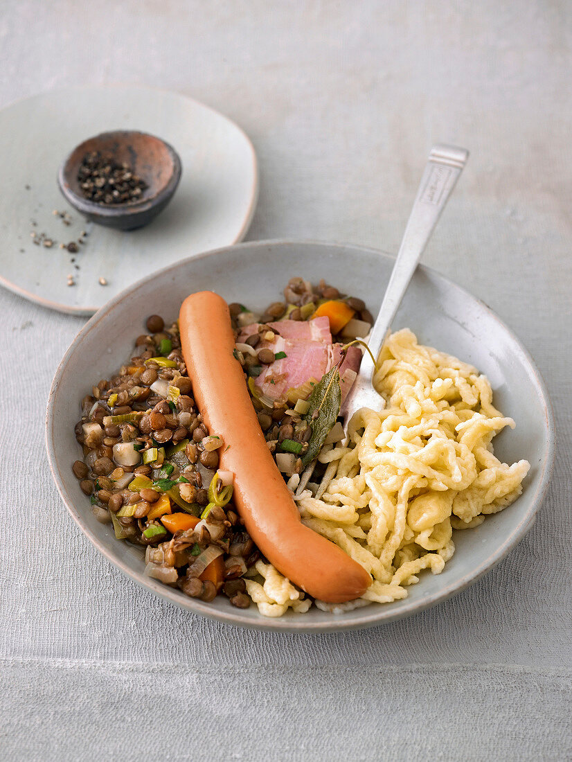Close-up of lentils and noodles with wieners on plate