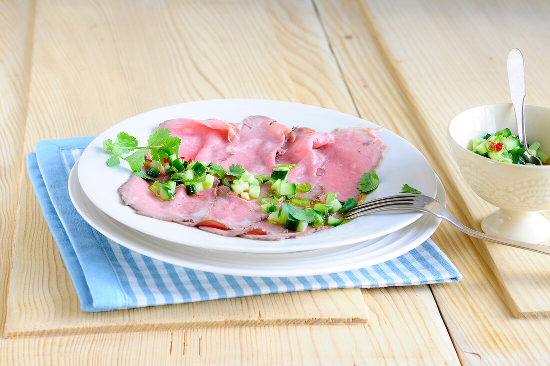 Roast beef with cucumber relish on plate