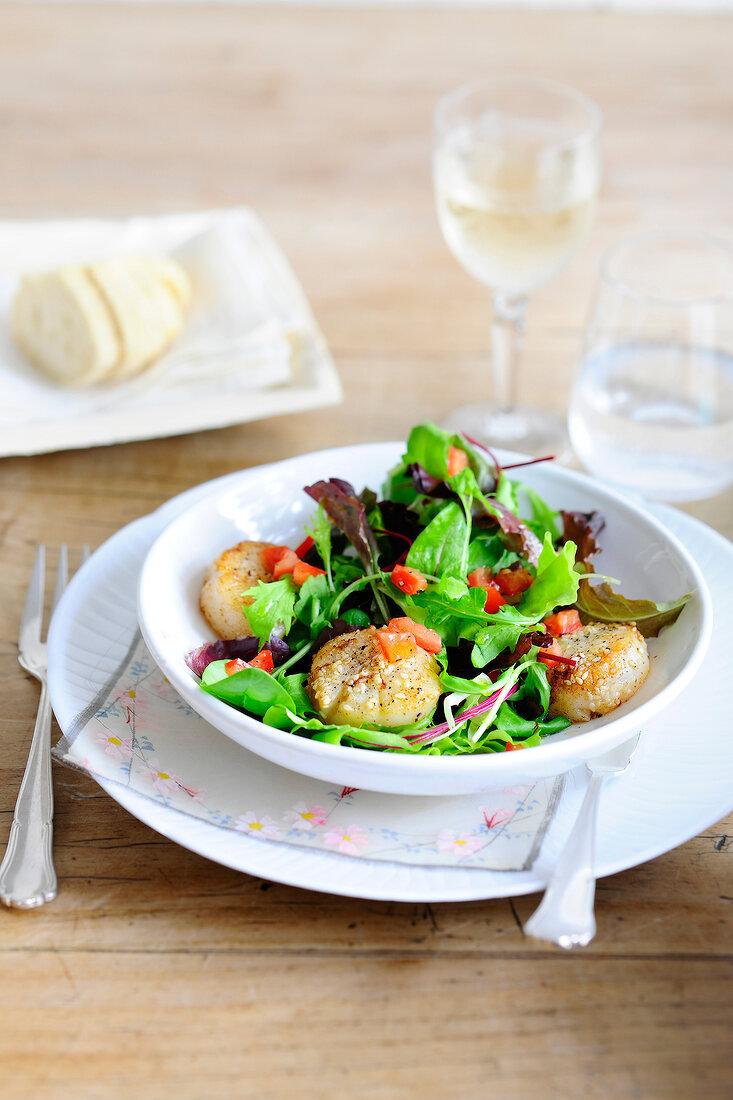 Leaf salad with scallops in bowl