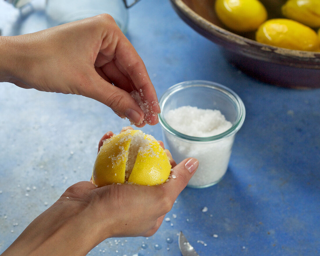 Close-up of hand filling salt in lemon