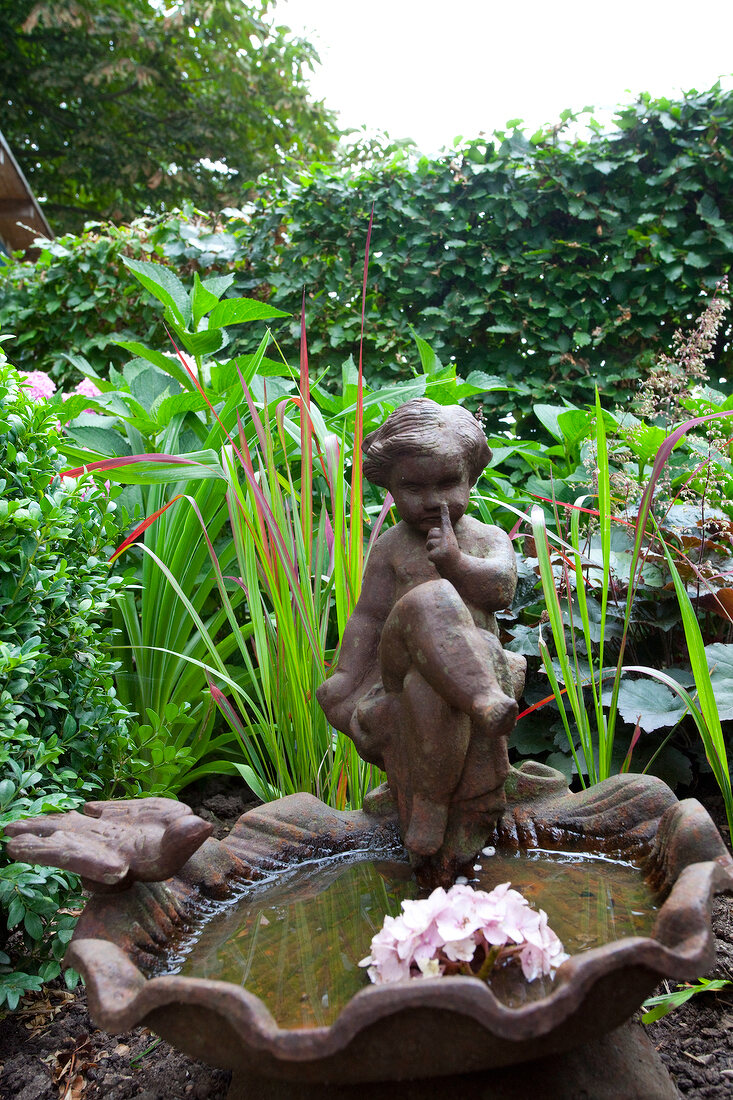 Fountain with child figurine in garden