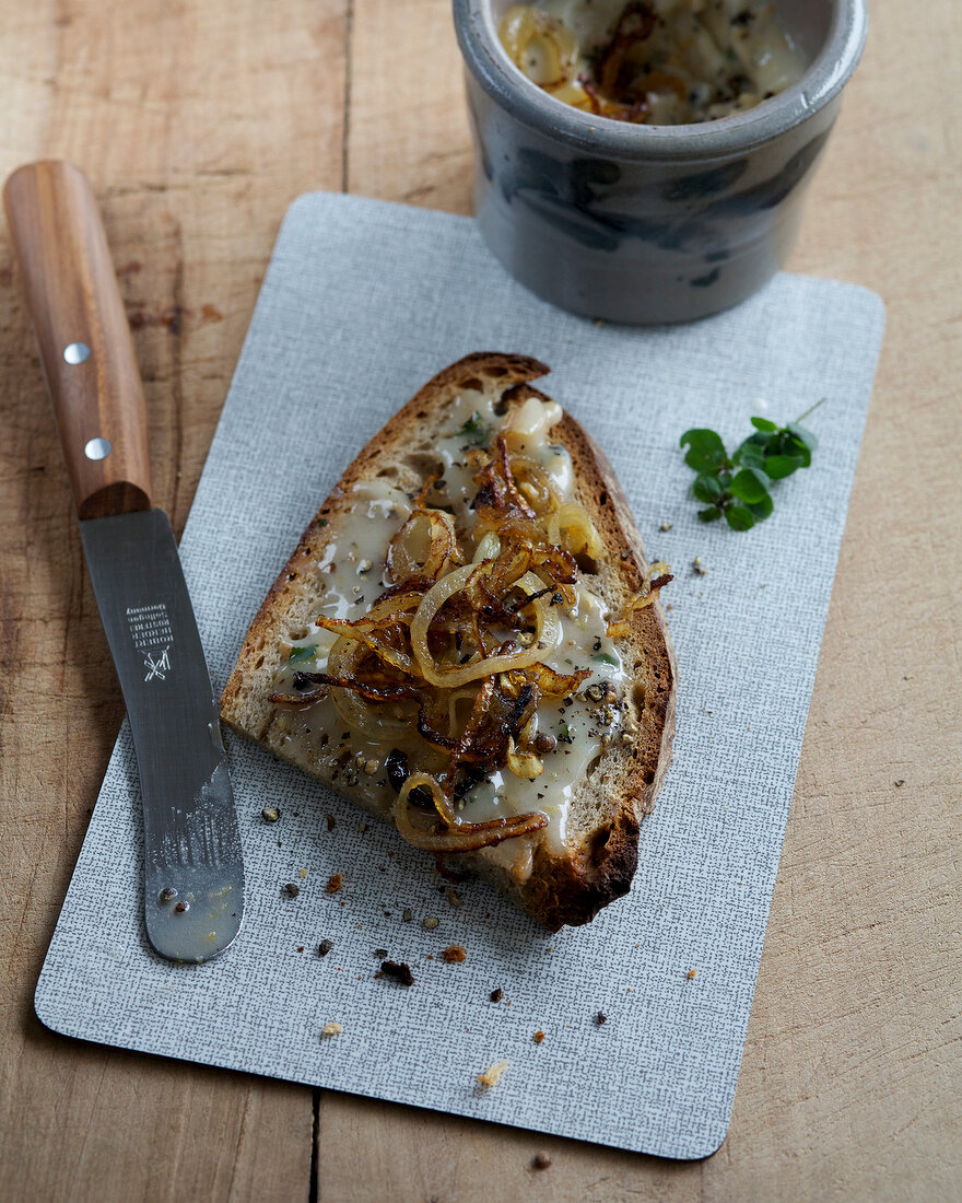 Homemade goose fat with bread and pepper on chopping board