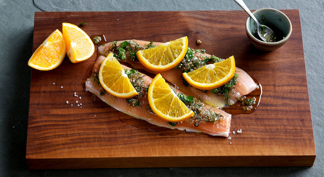 Fillets with spices and lime slices on wooden board