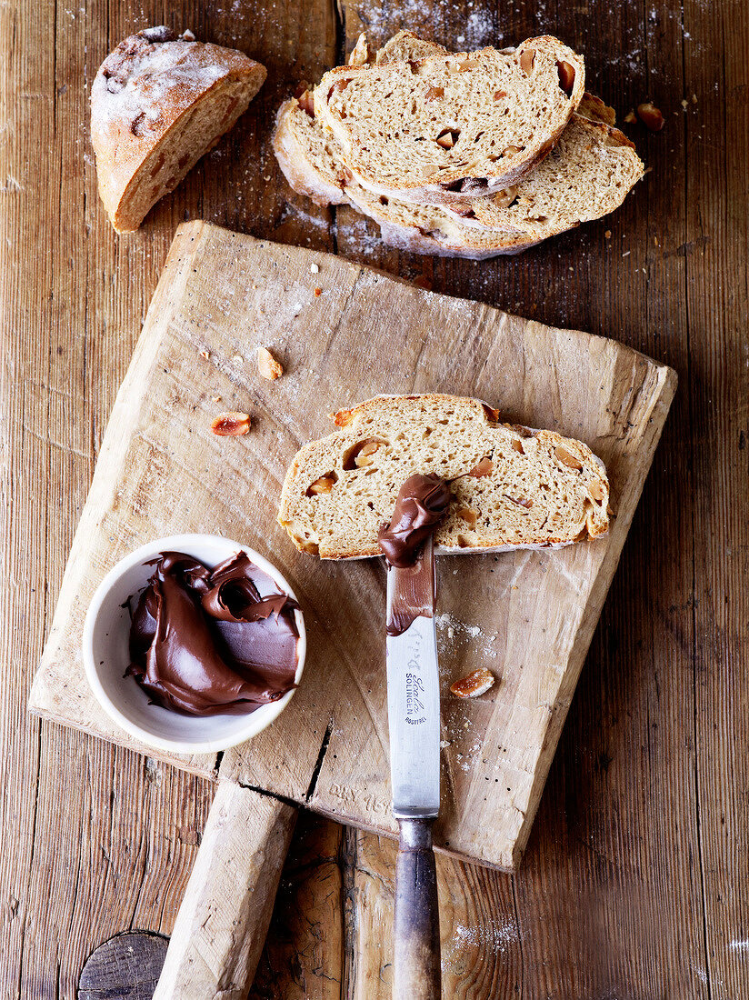 Brot, Eine Scheibe Erdnussbrot auf einem Brett, Nussnougatcreme