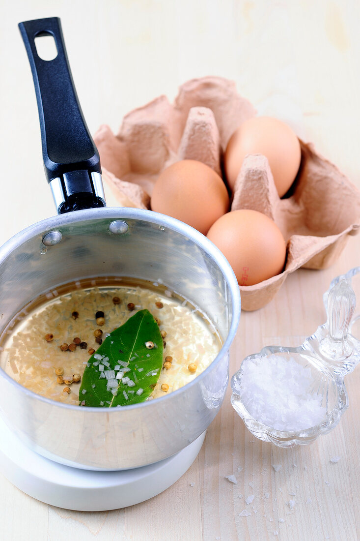 Butter and pepper in saucepan with eggs for preparation of hollandaise sauce, step 1