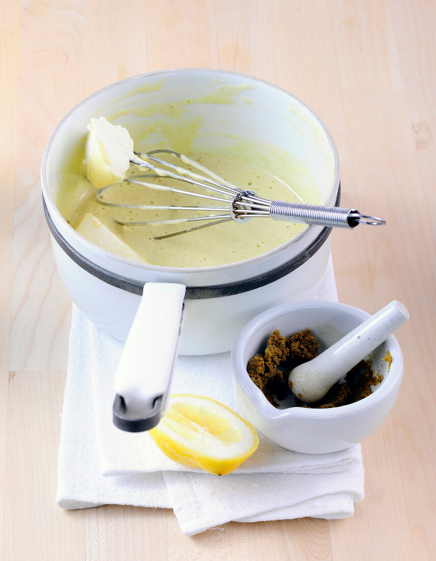 Sour cream being whisked in saucepan while preparing hollandaise sauce, step 4
