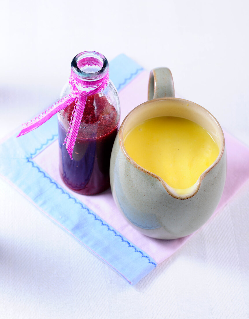 Mango lemon curd in jug and raspberry balsamic syrup in bottle 