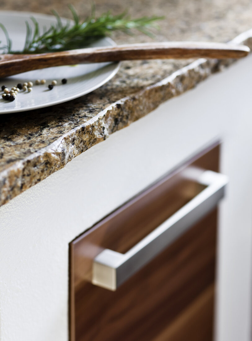 Close-up of kitchen countertop with granite edge and plate