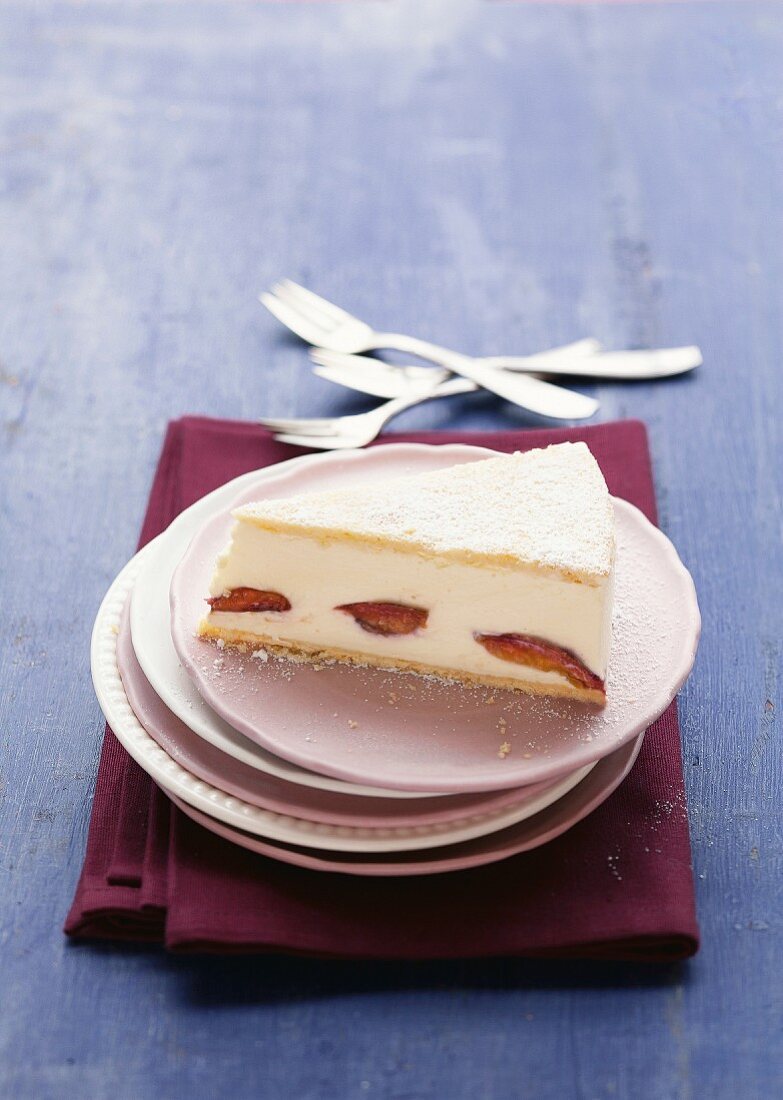 A slice of creamy cheesecake with plums