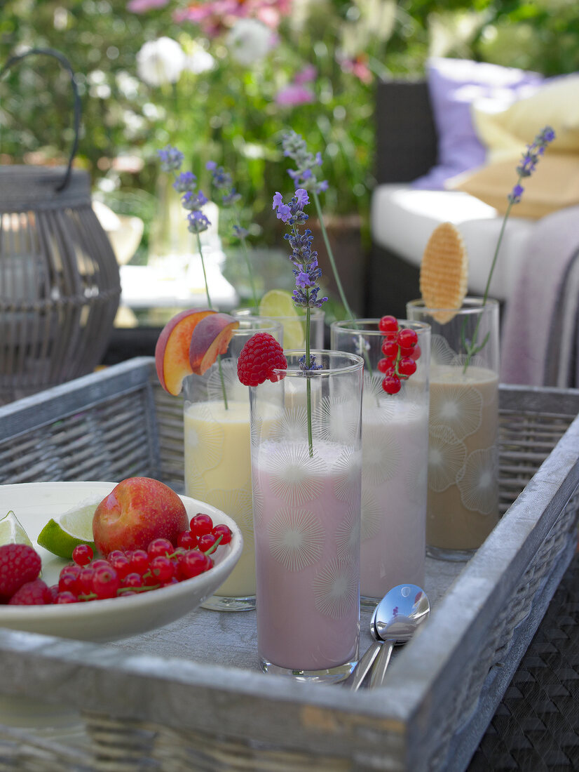 Tall glasses of fruit milkshakes in wicker tray