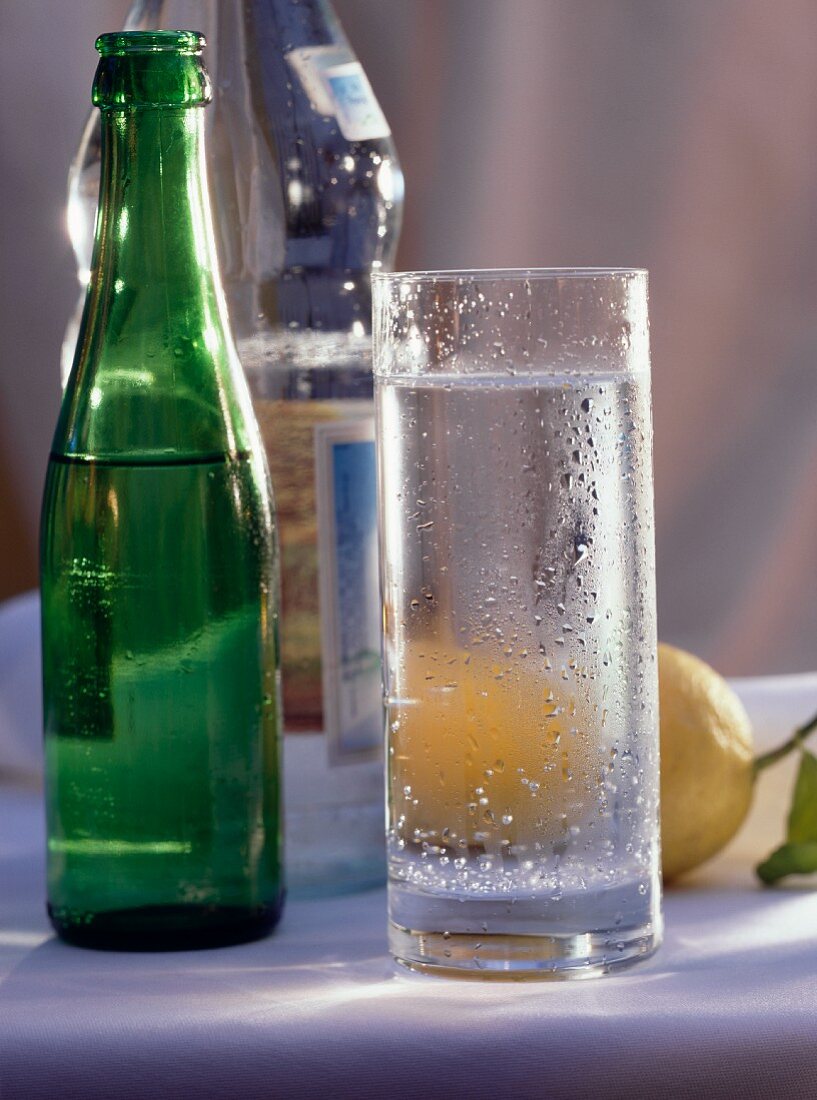 A Glass of Sparkling Water and Two Bottles