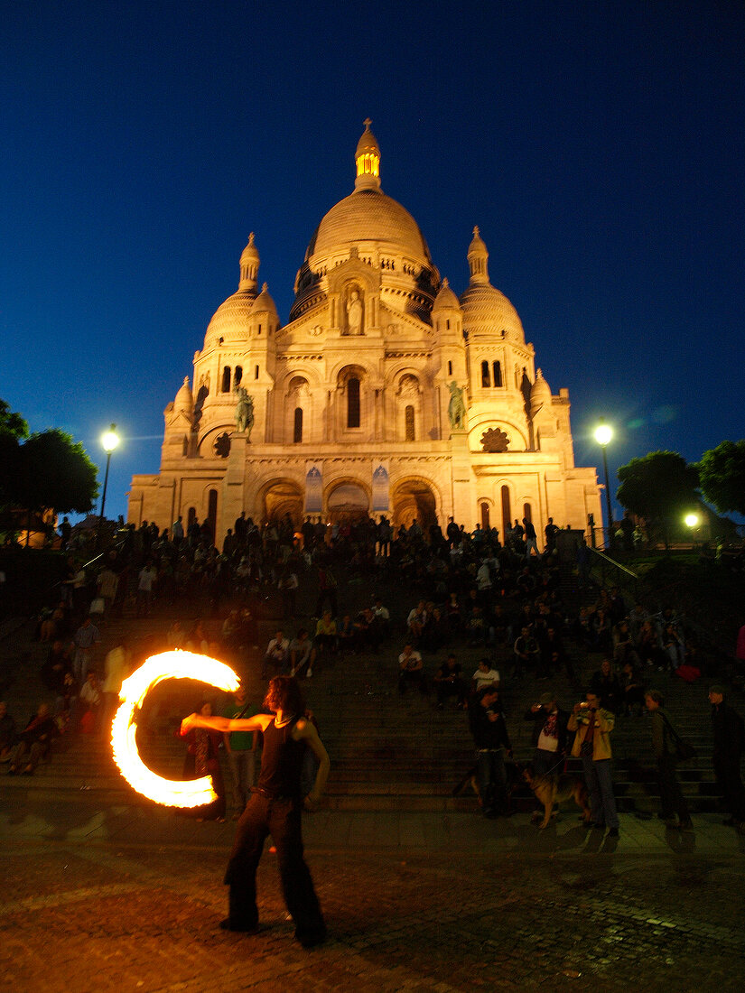 Spectators watching street play in front of Sacre Coeur at dusk, Paris, France