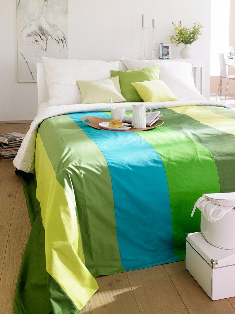 Doppelbett mit gestreiften Bettüberwurf in verschiedenen Grüntönen