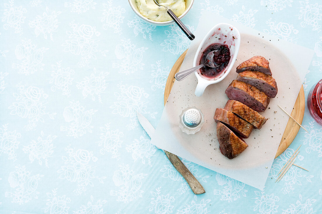 Duck breast with cranberry sauce on butter paper