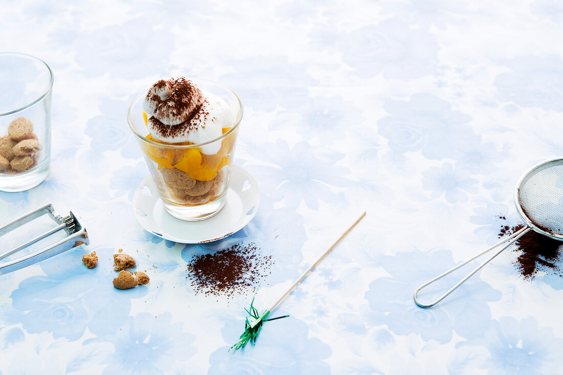 Dessert with cookie crumbs and cocoa powder in glass