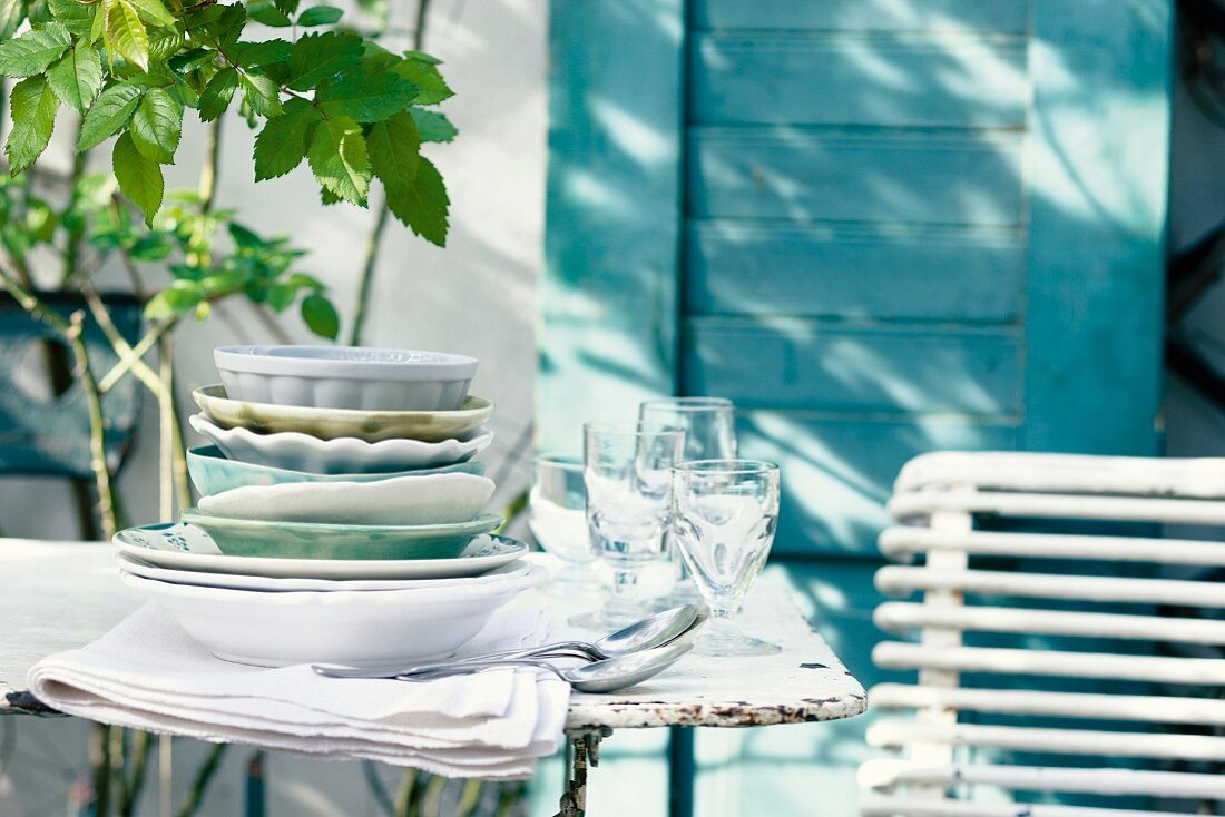 Crockery, glasses and cutlery on a patio table
