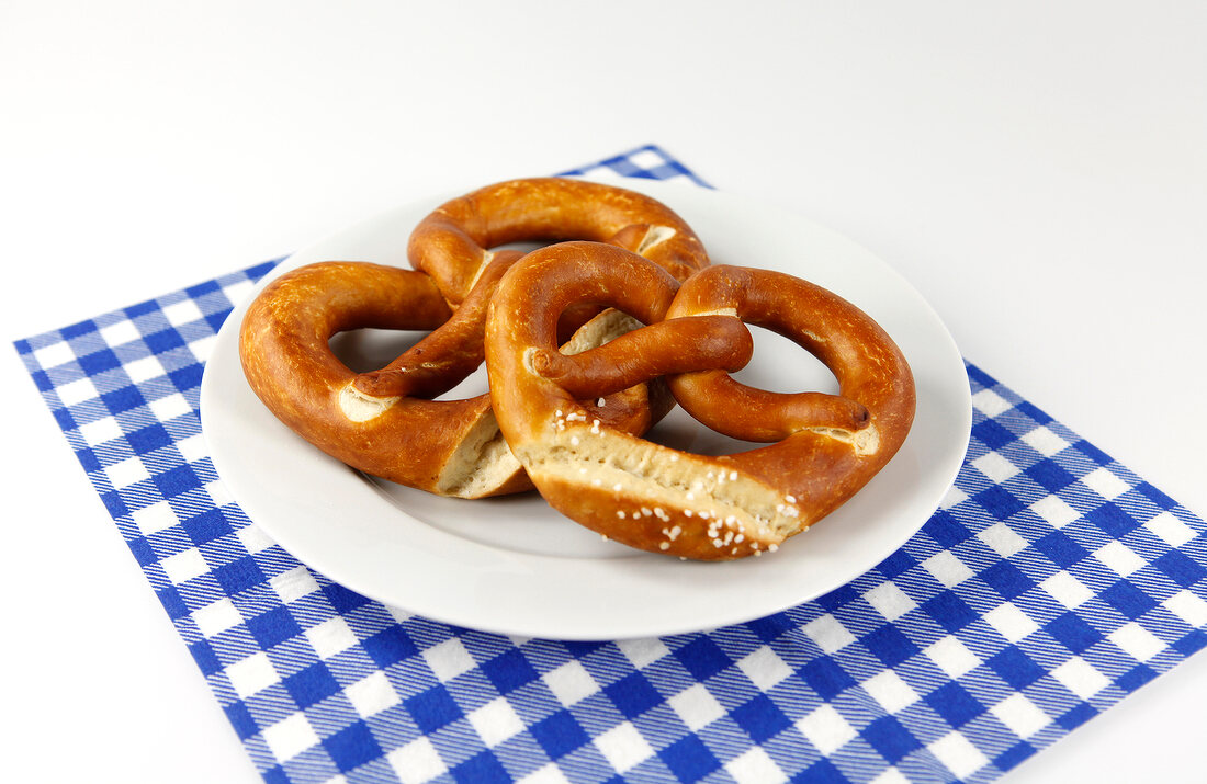 Plate with two pretzels on blue checked napkin