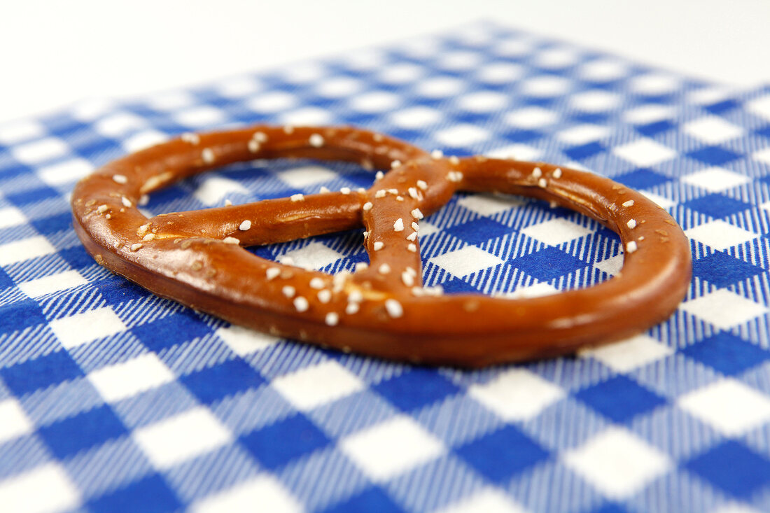 Close-up of pretzel on blue checked napkin