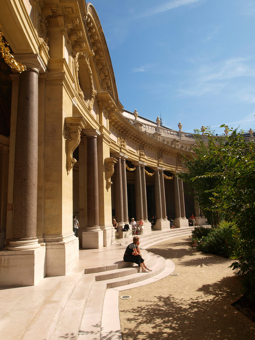 Woman sitting in courtyard of Petit Palais Museum in Paris, France