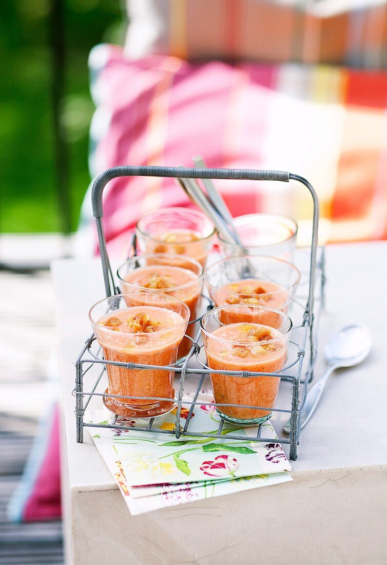 Gazpacho with croutons in jars on a table outside