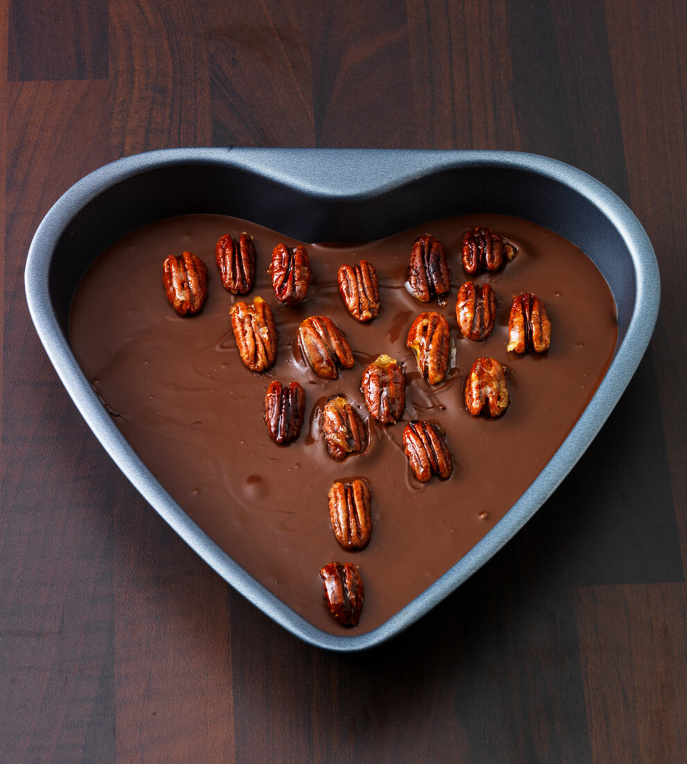 Melted chocolate with nuts in heart shaped tray, step 2