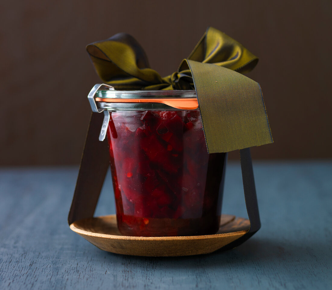 Close-up of beetroot chutney in glass jar with green ribbon