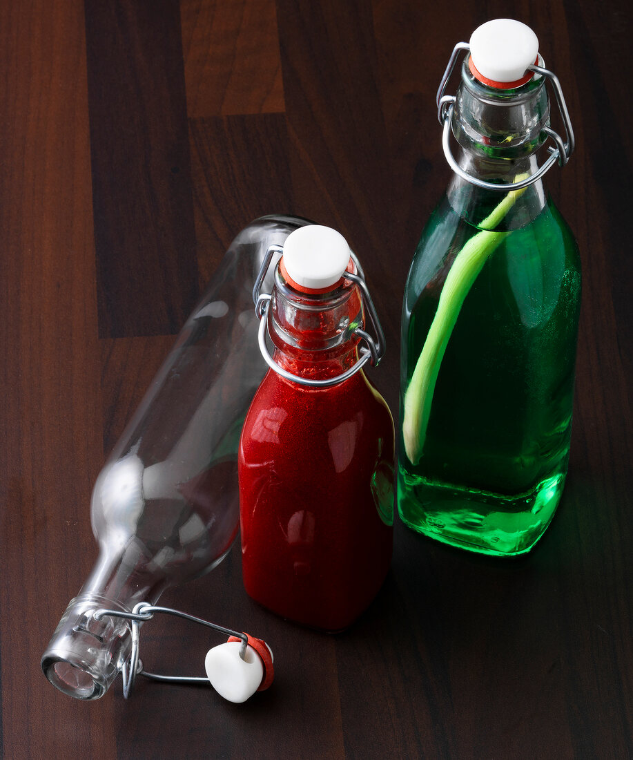 Close-up of lemon syrup and raspberry sauce in glass bottles