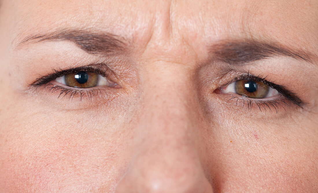 Close-up of brown eyed worried woman
