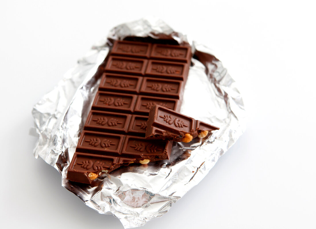 Close-up of chocolate with broken piece on silver paper