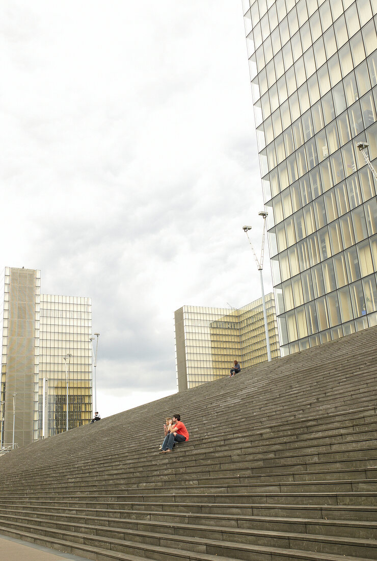 Man sitting on stairs in front of Rive Gauche in Paris, France
