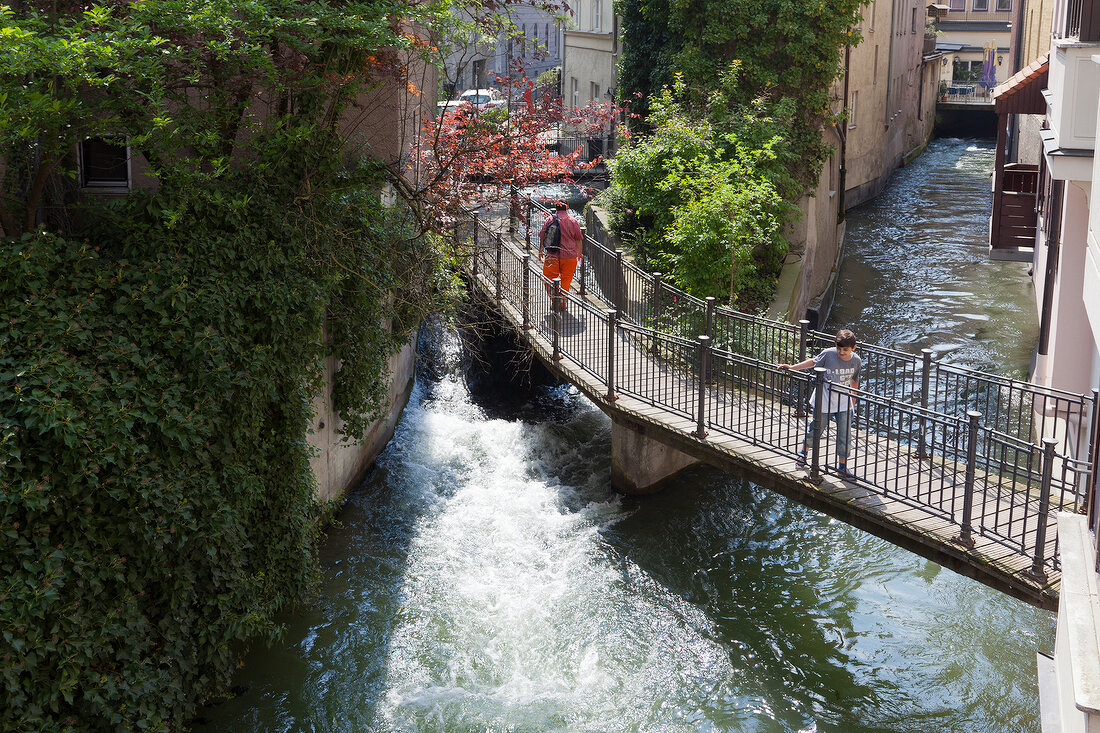 Boy standing on bridge in Augsburg, Bavaria, Germany