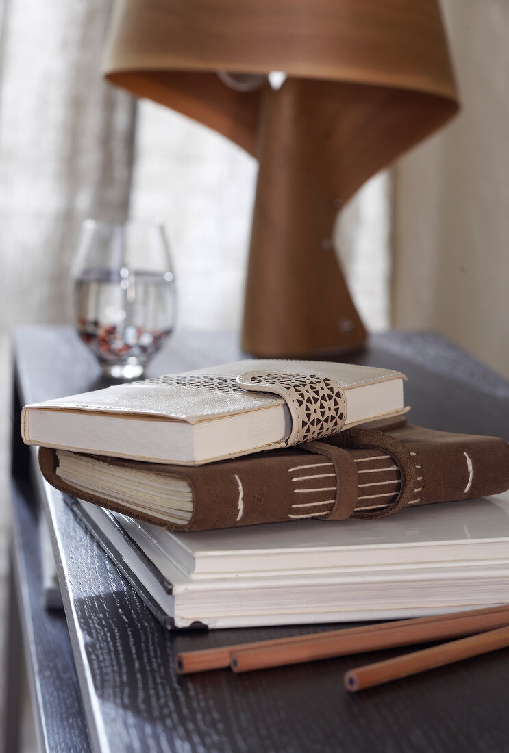 Close-up of leather books, pencils and diaries on table