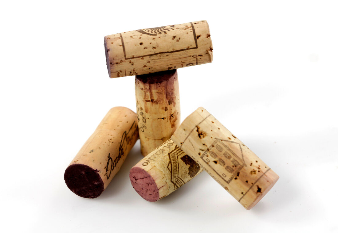 Close-up of five corks on white background