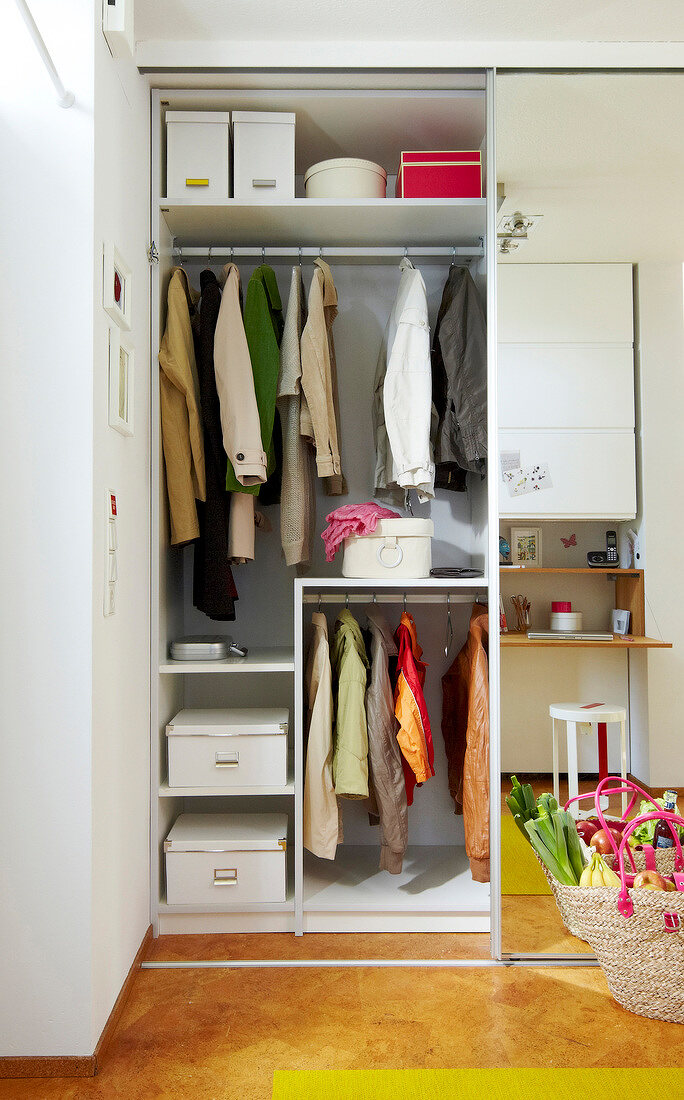 Clothes hanging in wardrobe shelves