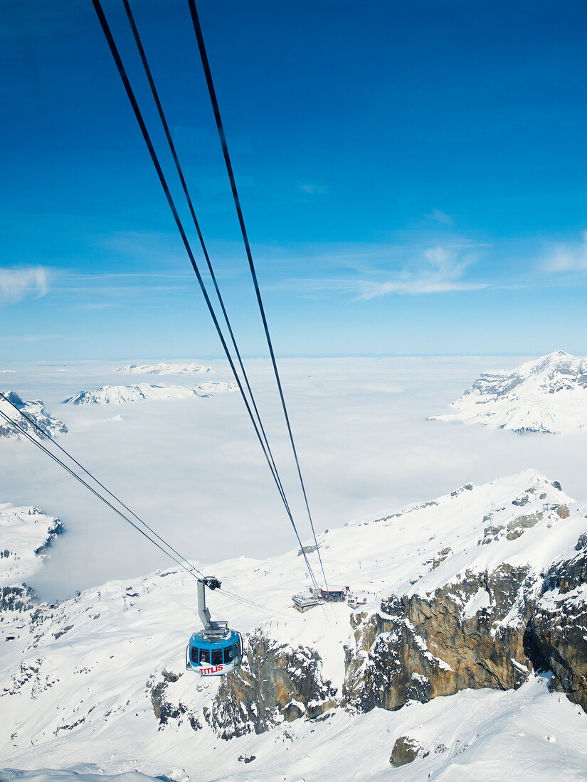 View of Titlis rotating cable car with snow covered mountains, Obwalden, Switzerland