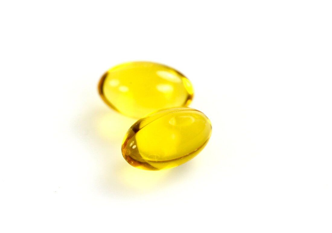 Close-up of two yellow coloured capsule on white background