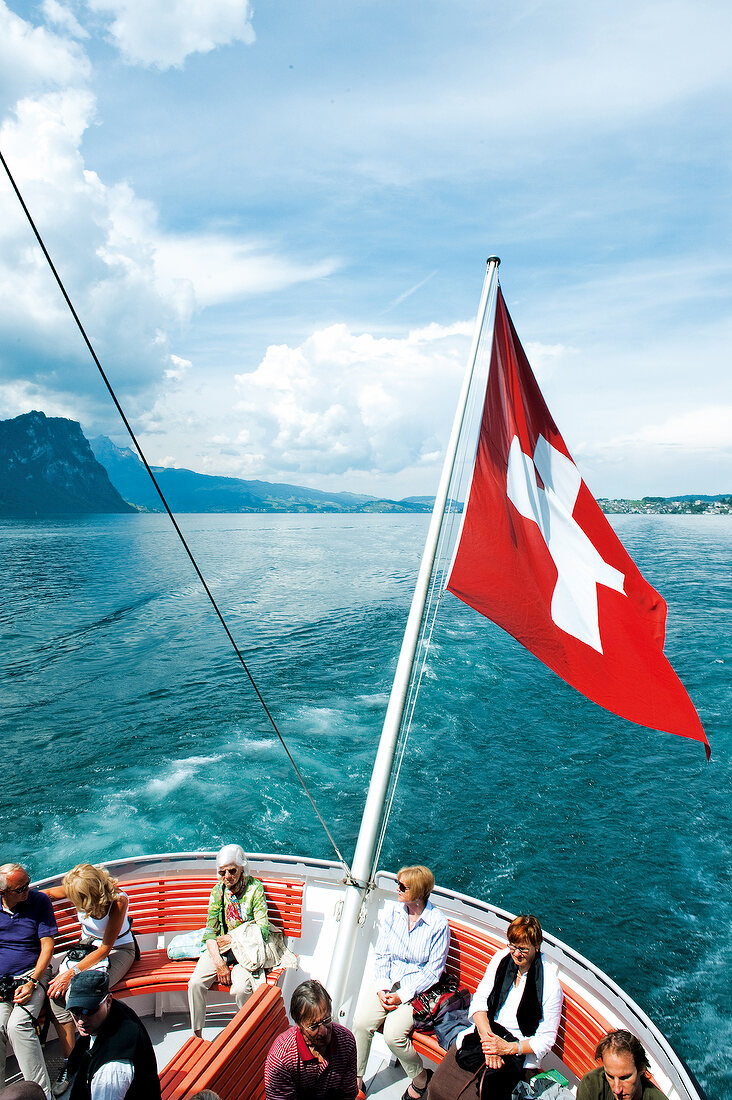 Tourists travelling in boat with national flag, Lucerne, Switzerland